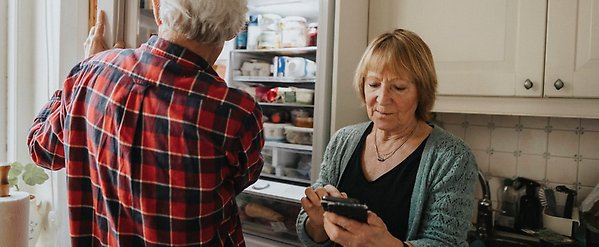 Äldre par tittar på mobiltelefon